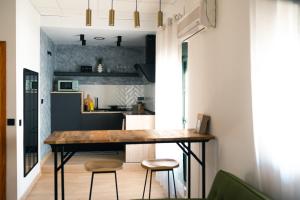 赫雷斯-德拉弗龙特拉El Olivar de Baro的厨房配有一张桌子和两张凳子