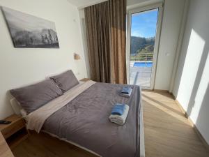 ヴルドニークにあるGreen panorama Vrdnikのベッドと大きな窓のある寝室 +31枚の写真