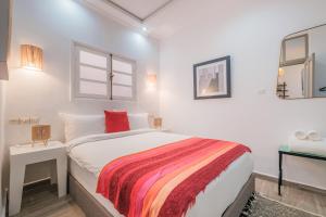 een witte slaapkamer met een bed en een raam bij Dar Said in Essaouira