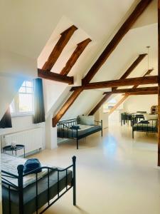 a attic room with several beds and tables at Apartmenthouse Singen in Singen +41 photos