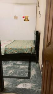 a room with two beds and a teddy bear on the wall at Ahil house in Lahore