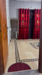 a room with red curtains and a room with a floor at Ahil house in Lahore
