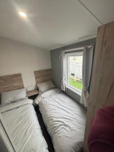 two beds in a small room with a window at A&l by the sea in Fleetwood