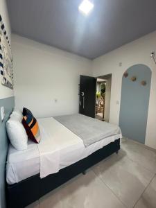 a bedroom with a bed with white sheets and pillows at Suítes Preguiça in Sao Jorge