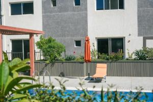 an orange umbrella and a chair next to a building at Mabaat-White Pearl Compound 600 B Villa 9 in Jeddah