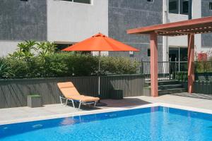 an orange umbrella and a chair next to a pool at Mabaat-White Pearl Compound 600 B Villa 9 in Jeddah