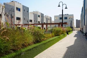 a sidewalk in a city with buildings and plants at Mabaat-White Pearl Compound 600 B Villa 16 in Jeddah