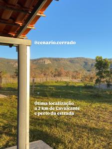 a sign in a field with mountains in the background at Cenário Cerrado in Cavalcante +23 photos
