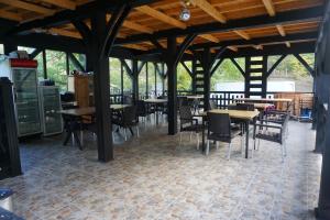 a dining room with tables and chairs in a building at Bujorul Oltului in Călimăneşti