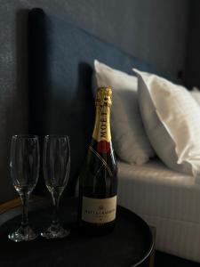 a bottle of champagne on a table with two glasses at The West Inn-Georgia Hotel in Kutaisi