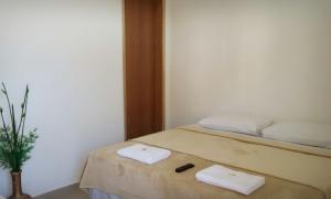 a bedroom with a bed with two towels on it at Hospedagem de Jesus in Aparecida