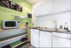 uma cozinha com armários brancos e um micro-ondas em Entertaining Studio em Wervik