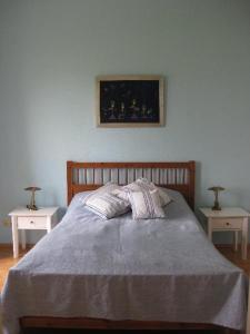 a bedroom with a bed with two nightstands and two tables at Das-Atelier in Lohme