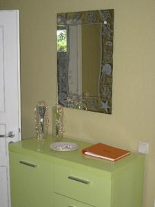 a bathroom with a green dresser with a mirror at Das-Atelier in Lohme +3 photos