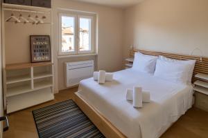 ein Schlafzimmer mit einem großen weißen Bett mit zwei Kerzen darauf in der Unterkunft Front Beach Apartments - Attic in Viareggio