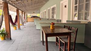 a wooden table with chairs and a vase on it at Mares e Flores de Bombinhas in Bombinhas
