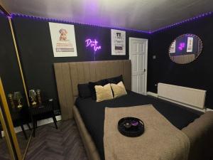 a bedroom with a bed and purple lights on the wall at A Star Living in Liversedge