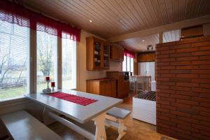 a kitchen with a table and some windows and a table and chairs at Spacious detached house for a larger group in Rovaniemi