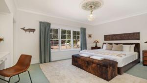 a bedroom with a bed and a chair and a window at Southern Grace in Bowral