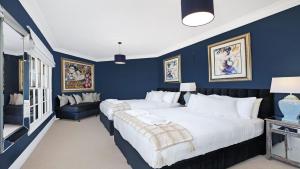 a blue bedroom with two beds and a couch at Southern Grace in Bowral +30 photos