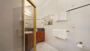 a bathroom with a shower and a sink and a mirror at Southern Grace in Bowral