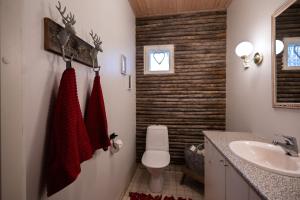 a bathroom with a white toilet and a sink at Spacious detached house for a larger group in Rovaniemi