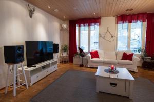 a living room with a couch and a flat screen tv at Spacious detached house for a larger group in Rovaniemi