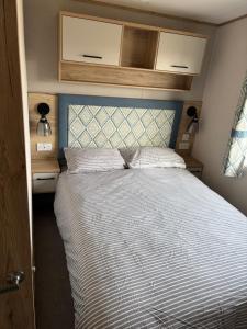 a bedroom with a large bed with a blue headboard at Driftwood dreams in Skipsea +16 photos
