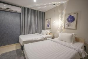twee bedden in een hotelkamer met witte lakens bij Mabaat-White Pearl Compound 600 B Villa 3 in Jeddah +28 foto's