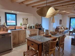 a kitchen and living room with a table and chairs at La Clef des songes in Lafarre