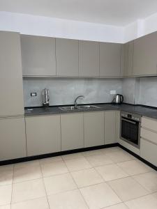 TiraneThe 5 Maji Escape的带白色橱柜和水槽的厨房