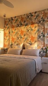 a bedroom with a large bed with a floral wall at Mirada Do Roxo in Oia