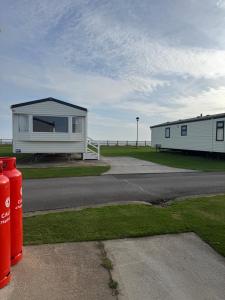 a house on the side of a road next to the ocean at Steph's Haven in Skipsea