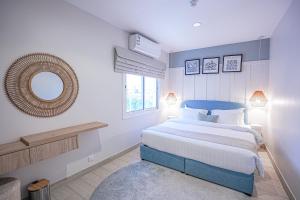 a bedroom with a large bed and a mirror at Mabaat-White Pearl Compound 600 D Villa 28 in Jeddah +17 photos