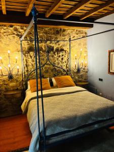 a bedroom with a metal canopy bed with orange pillows at Posada-Finca Fuentes Carrionas in Camasobres