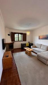 a living room with a couch and a table at Quinta de Carvalhal - Casa de Campo in Guimarães +37 photos