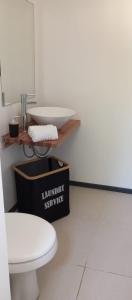 a bathroom with a white toilet and a sink at El refugio in La Paloma +11 photos