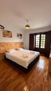 a bedroom with a large bed and a wooden floor at Quinta de Carvalhal - Casa de Campo in Guimarães +37 photos