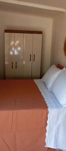 a bedroom with a bed with white sheets and cabinets at El refugio in La Paloma