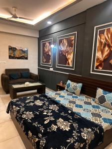 een slaapkamer met een bed en een bank bij Bell Rooms Luxury studio Apartment in Noida +29 foto's