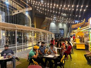 een groep mensen die aan tafels in een gebouw zitten bij Bell Rooms Luxury studio Apartment in Noida