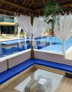 a swimming pool with white curtains in the middle at Casa Milagres Morada do toque- By milagres hospitalidade in São Miguel dos Milagres