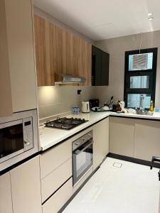 a kitchen with a stove and a microwave at Al Furat Apartment in Seeb