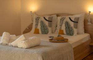 a white bed with pillows and towels on it at Apartment Zdravets, in the heart of the old city in Veliko Tŭrnovo