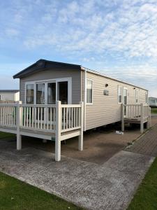 a mobile home with a porch and a deck at Driftwood dreams in Skipsea
