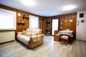 una sala de estar con un sofá y una mesa en Casa Liscidini, en Aprica