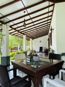 a dining room with a wooden table and chairs at The Garden Grove Villa in Yatiyana