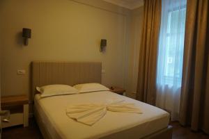 1 dormitorio con cama blanca con arco en Bujorul Oltului, en Călimăneşti