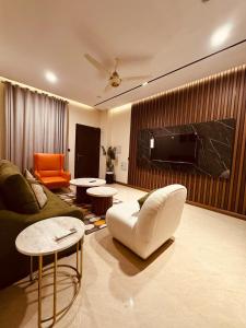 a living room with a couch and a tv at Zeta Mall Luxury Apartments by Wall Street Rooftop Pool Access in Islamabad