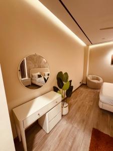 a room with a mirror and a desk and a bed at Zeta Mall Luxury Apartments by Wall Street Rooftop Pool Access in Islamabad +2 photos